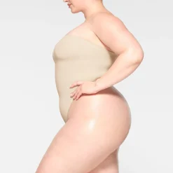 SEAMLESS SCULPT STRAPLESS THONG BODYSUIT | SAND